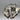 Close-up of silver dog brooch's head and body displaying sculpted details and patina.