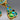 Close-up of earring bottom with green, blue stones and textured gold